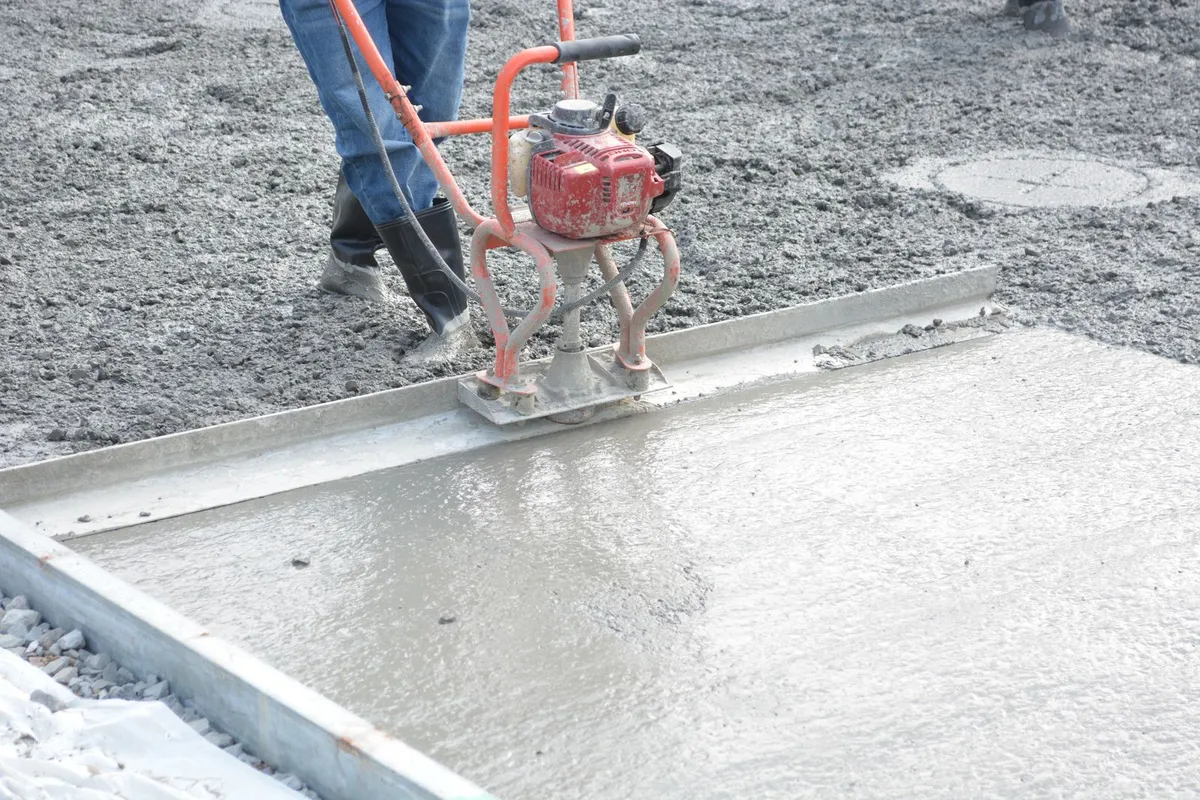 Concrete slab being leveled with a power screed