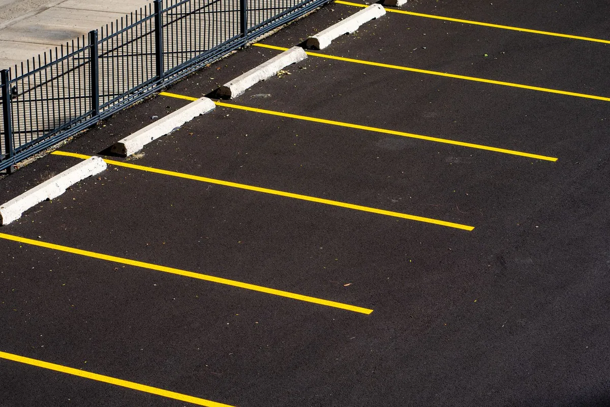 Fresh yellow parking stall lines on new asphalt